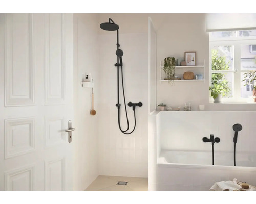 Helles Badezimmer mit ebenerdiger Dusche und Badewanne inklusive schwarzer Armaturen und moderner Einrichtung.