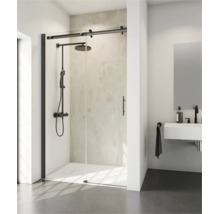 Cabine de douche moderne avec porte coulissante et quincaillerie noire, installée dans une salle de bain lumineuse avec douche pluie et lavabo.