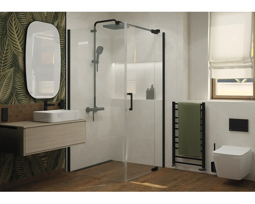 Salle de bain moderne avec cabine de douche en verre, lavabo suspendu, miroir ovale et toilettes suspendues devant un mur à motif végétal.