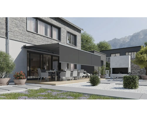 Store de terrasse moderne avec lambrequin enroulable sur une maison en brique avec espace jardin et salon de jardin.