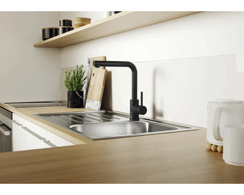 Évier de cuisine moderne en acier inoxydable avec robinet mitigeur noir sur un plan de travail aspect bois dans une cuisine lumineuse.