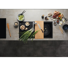 Vue de dessus d'un évier moderne en composite avec planche à découper intégrée et mitigeur de cuisine dans un plan de travail préparé.