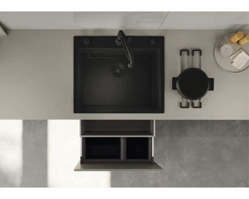 Vue de dessus d'une cuisine moderne avec évier noir, mitigeur, plan de travail, casserole et système de tri des déchets dans le meuble bas.