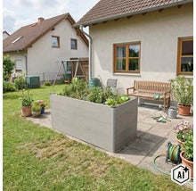 Jardinière surélevée rectangulaire en plastique aspect bois sur une terrasse en pierre dans un jardin avec maison, banc et plantes. (Image AI modified or generated)