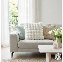 Un salon lumineux avec un canapé décoré de trois coussins différents et une table basse avec un vase rempli de fleurs. (Image AI modified or generated)