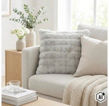 Quadratisches Sofakissen mit weichem Webpelzbezug in strukturierter Optik auf einem modernen Sofa platziert. (Image AI modified or generated)