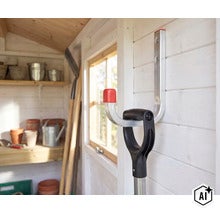 Gerätehalter zur Wandmontage in einem Gartenhaus, an dem ein Spaten aufgehängt ist. (Image AI modified or generated)