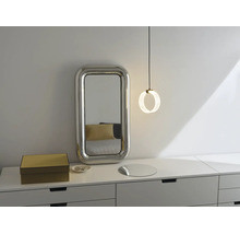 Moderne Kommode mit rechteckigem Wandspiegel mit breitem Rahmen und einer runden Pendelleuchte in einem hellen Schlafzimmer