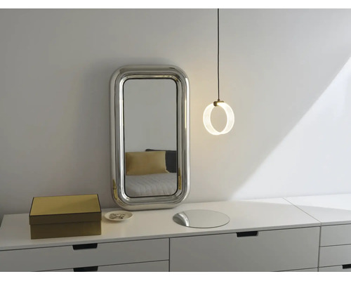 Moderne Kommode mit rechteckigem Wandspiegel mit breitem Rahmen und einer runden Pendelleuchte in einem hellen Schlafzimmer