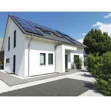 Maison individuelle moderne avec panneaux solaires sur le toit et aménagement extérieur soigné avec chemin pavé et gravier.