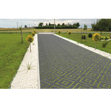 Une allée avec des pavés carrés formant un motif géométrique, bordée de bandes de graviers décoratifs et de petits arbres en boule.