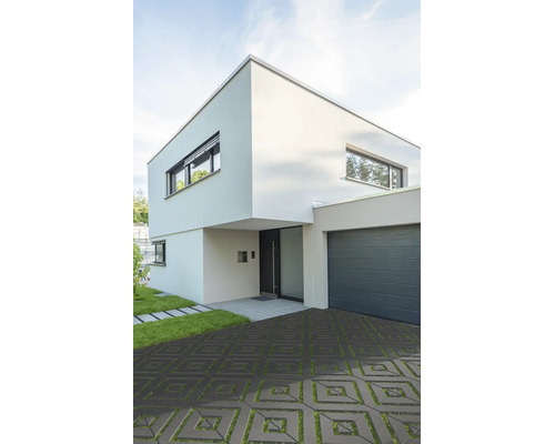 Maison moderne à deux étages avec pavés gazon carrés dans l'allée et garage attenant.