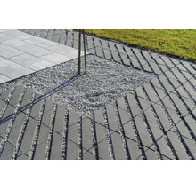 Chemin de jardin en pavés de béton à motif de grille avec lit de gravier, pelouse adjacente et dalles de terrasse.