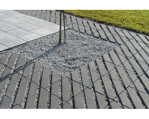 Chemin de jardin en pavés de béton à motif de grille avec lit de gravier, pelouse adjacente et dalles de terrasse.