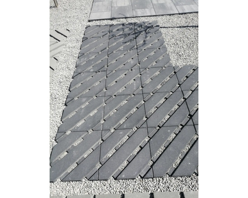 Chemin piétonnier en pavés de béton posés en diagonale avec joints sur une surface en gravier à l extérieur