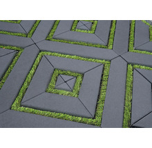 Pavés en béton de forme rectangulaire posés avec des joints en gazon synthétique dans un motif géométrique pour le revêtement extérieur.