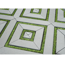 Pavés géométriques en béton avec joints en gazon formant un motif carré.