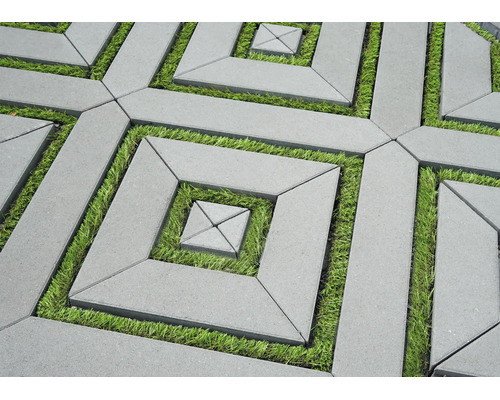 Pavés géométriques en béton avec joints en gazon formant un motif carré.