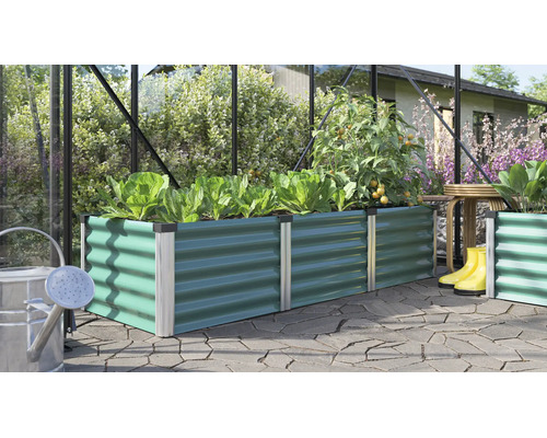 Jardinière surélevée rectangulaire en métal avec profil ondulé dans une serre plantée de laitues et de tomates sur une terrasse pavée