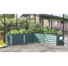 Jardinière surélevée en angle en métal dans une serre avec divers légumes sur une terrasse