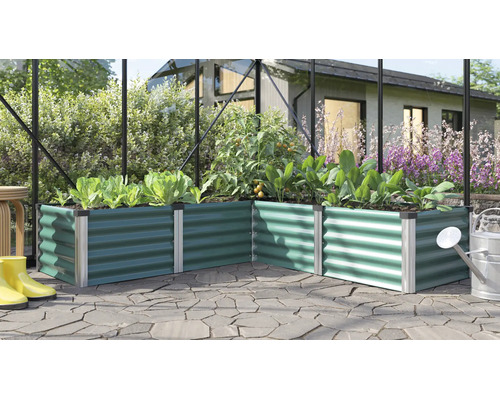 Jardinière surélevée en angle en métal dans une serre avec divers légumes sur une terrasse