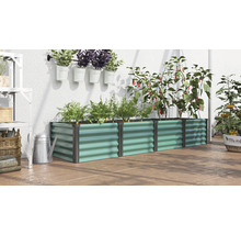 Jardinière surélevée rectangulaire en métal ondulé remplie de plantes dans une serre avec arrosoir et pots suspendus