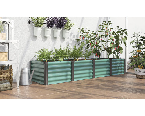 Jardinière surélevée rectangulaire en métal ondulé remplie de plantes dans une serre avec arrosoir et pots suspendus