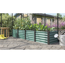 Jardinière surélevée rectangulaire en métal avec structure ondulée dans une serre avec des plantes et des outils de jardinage