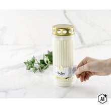 Bougie funéraire avec couvercle et étiquette Hofer Friedlicht dans une main (Image AI modified or generated)