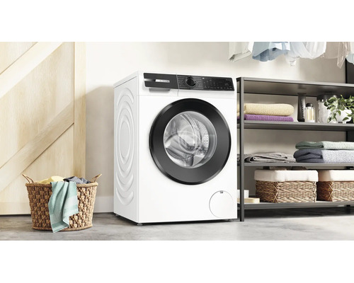 Lave-linge Bosch dans une buanderie moderne avec panier, étagères et linge plié.