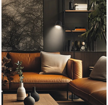 Salon moderne avec canapé en cuir, lampadaire et décoration sur étagère, aménagement intérieur élégant.