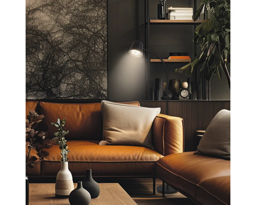 Salon moderne avec canapé en cuir, lampadaire et décoration sur étagère, aménagement intérieur élégant.