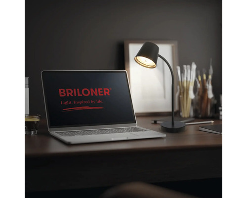 Schreibtischlampe mit flexiblem Arm auf einem Arbeitsplatz mit Laptop und Briloner Logo auf dem Bildschirm