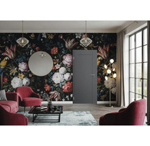 Eine elegante Zimmertür in einem modern eingerichteten Wohnzimmer mit blumiger Mustertapete, roten Sesseln und goldenen Akzenten.