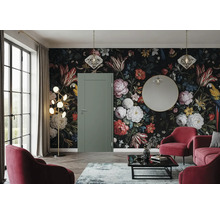 Eine grüne Zimmertür in einem Wohnzimmer mit floraler Tapete, runden Sesseln, einer modernen Stehlampe und einem runden Spiegel.