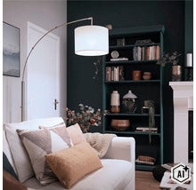 Lampadaire arc moderne avec abat-jour en tissu à côté d'un canapé dans un salon confortable avec étagère sombre et cheminée. (Image AI modified or generated)