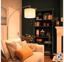 Lampadaire moderne avec abat-jour en tissu à côté d'un canapé dans un salon confortable avec une étagère sombre et une cheminée. (Image AI modified or generated)