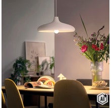 Lampe suspendue moderne au-dessus d une table à manger avec un bouquet de fleurs et de la décoration en arrière-plan dans un espace lumineux. (Image AI modified or generated)