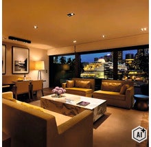 Luxuriöser Wohnraum mit modernen Sofas, einem Marmor Couchtisch und Blick auf ein Kreuzfahrtschiff im Hafen bei Nacht. (Image AI modified or generated)