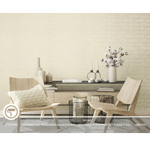Salon avec papier peint intissé beige aspect brique, combiné avec des chaises en bois clair, une commode moderne et des accessoires décoratifs.