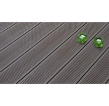 Terrassendielen aus WPC mit Riffelung auf der Oberfläche und zwei quadratischen Teelichthaltern aus Glas.