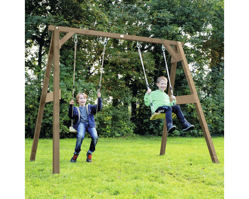 Deux enfants jouent sur une balançoire en bois dans le jardin avec deux sièges et un cadre en A robuste.