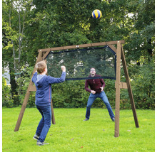 Un enfant et un adulte jouent avec un ballon autour d'une structure de jeu en bois avec filet dans un jardin.
