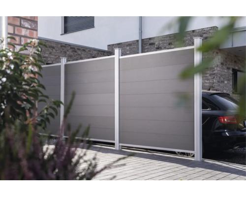 Clôture de jardin moderne en plastique avec poteaux métalliques devant une maison avec allée.