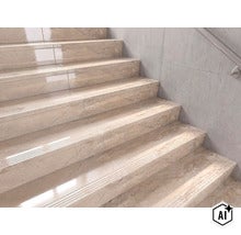 Escalier revêtu de carreaux de marche en aspect marbre avec bord profilé devant un mur clair avec main courante. (Image AI modified or generated)