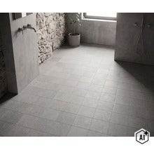 Badezimmer mit quadratischen Bodenfliesen in Steinoptik, Natursteinwand und moderner Sanitärausstattung. (Image AI modified or generated)