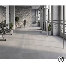 Geräumiges Fitnessstudio mit großen quadratischen Fliesen, einer Natursteinwand und modernen Trainingsgeräten in heller, funktionaler Umgebung. (Image AI modified or generated)