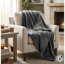 Un plaid en polaire douce drape sur un fauteuil dans un salon chaleureux avec une cheminee. (Image AI modified or generated)