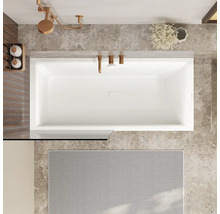 Baignoire rectangulaire vue de dessus dans une salle de bain moderne avec carrelage en marbre et robinetterie aspect métal.