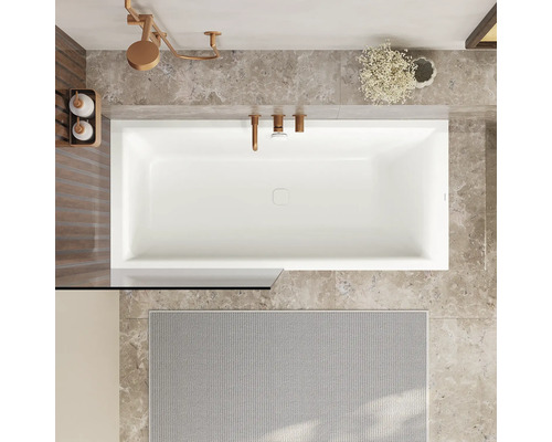 Baignoire rectangulaire vue de dessus dans une salle de bain moderne avec carrelage en marbre et robinetterie aspect métal.